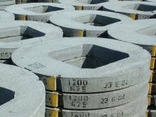 Circular 1200 cover slabs with square access openings stacked in the yard
