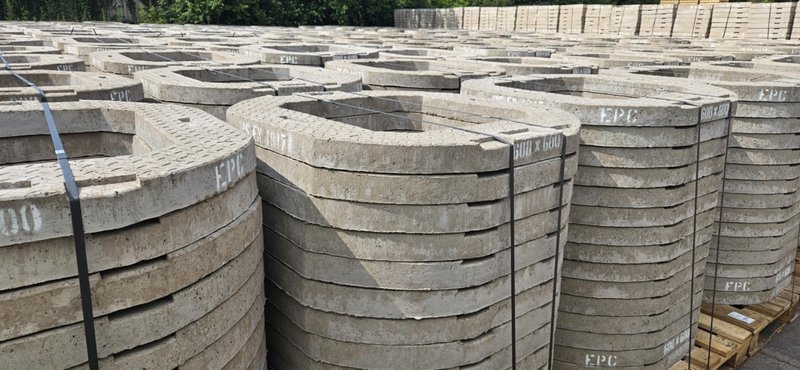 Rows of concrete seating rings stacked across a storage yard