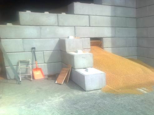 Golden grain piled into a corner bay of interlocking block walling