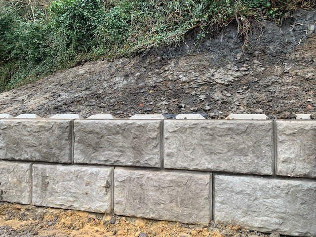 Stone-textured Vee-Rock walling blocks forming a retaining wall below a steep bank