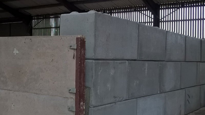 Duo blocks stacked into a silage clamp wall beside an open farm building