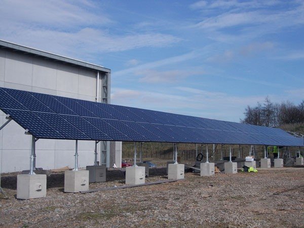 Ballast blocks anchoring the frames of a ground-mounted solar panel array