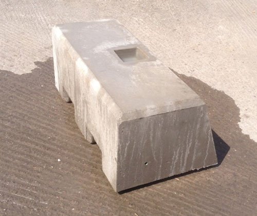 Long kentledge ballast block with a central lifting pocket on a concrete yard