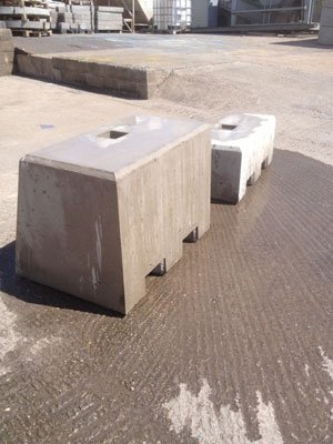 Kentledge ballast blocks in two sizes standing on a concrete yard