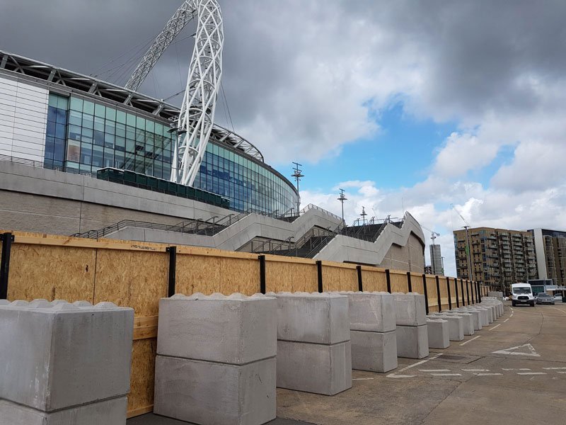 Kentledge blocks ballasting timber hoarding outside Wembley Stadium