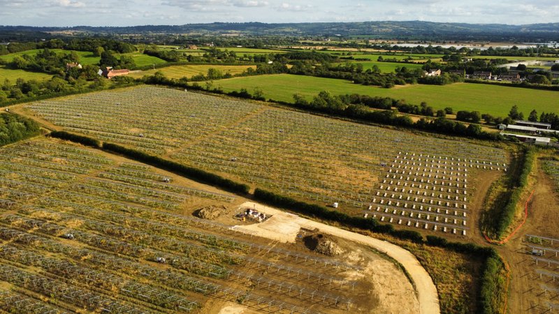 Aerial view of a large solar panel array laid out across open farmland