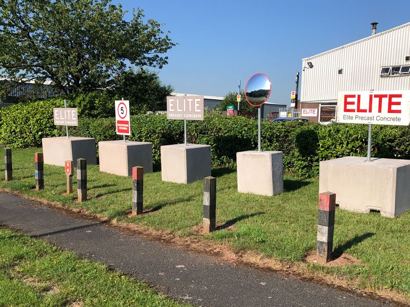 Non-drill concrete post blocks holding roadside signage along a grass verge