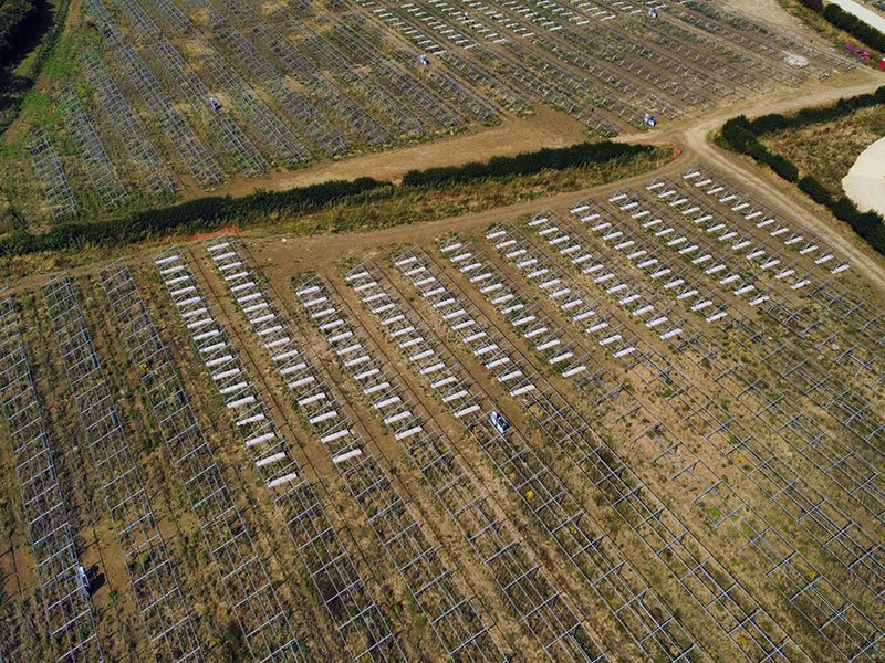 Aerial view of solar array rows spreading across a ballasted site