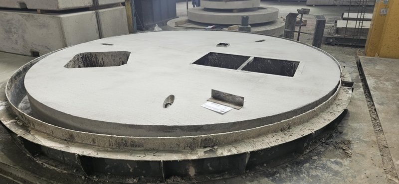 Large circular cover slab with three rectangular openings on a casting bed