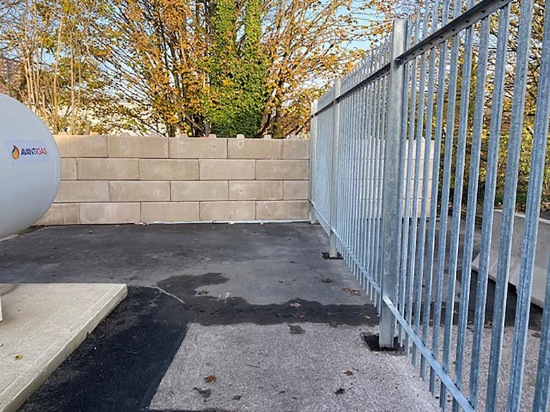 Duo block blast wall running alongside a steel palisade security fence