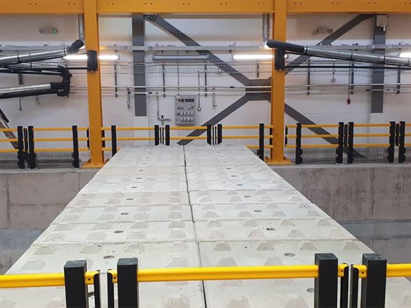 Interlocking blocks forming a low bunker wall inside an industrial building
