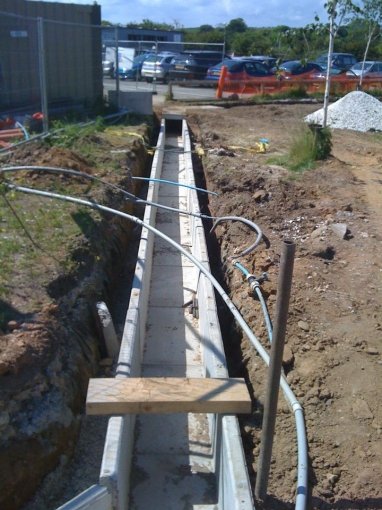 Cable trough run laid in an open trench with cables being drawn through