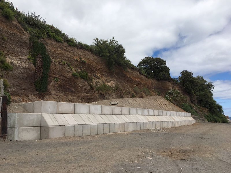 Legato block wall built at the foot of an eroding earth cliff