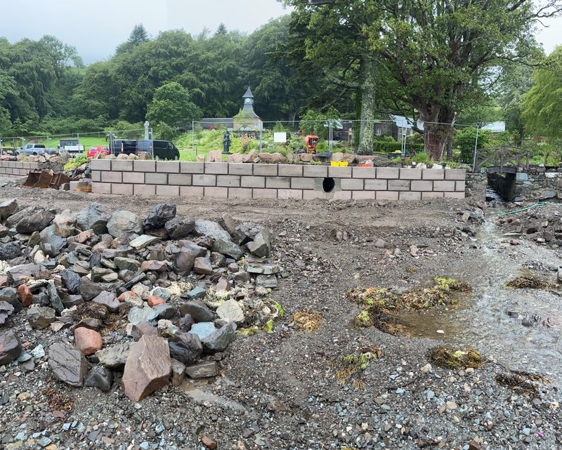 Retainer-Rock walling retaining a bank above a boulder-strewn river bed