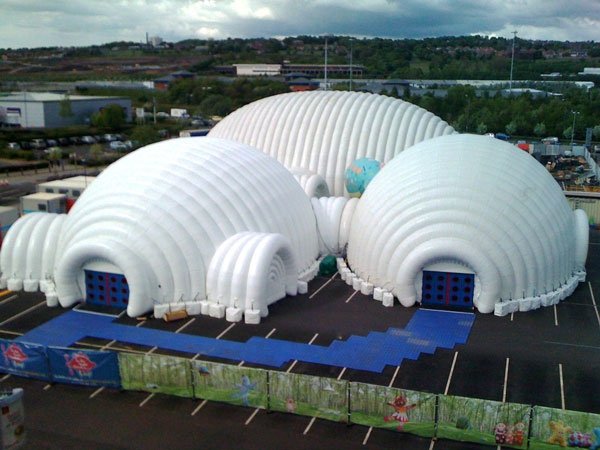 Inflatable dome event venue with blue walkways on a fenced hardstanding site