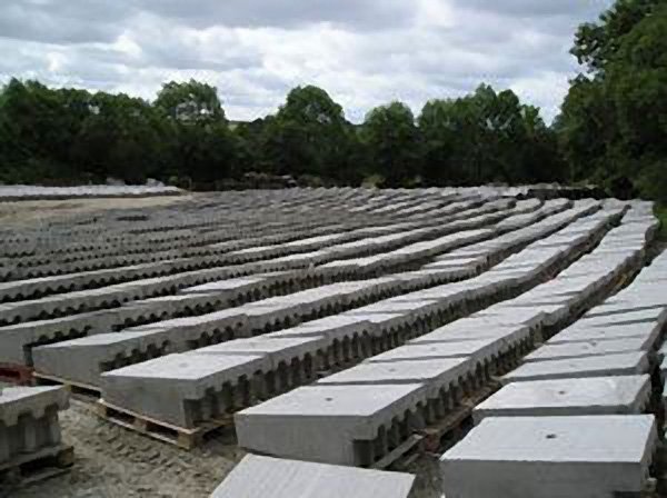 Rows of precast dam spillway blocks laid out in a storage yard