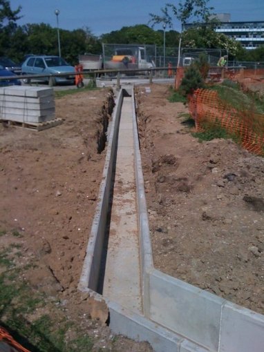 Precast cable trough run laid along a trench on a construction site