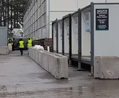 Temporary vertical concrete barriers protecting a line of site accommodation cabins
