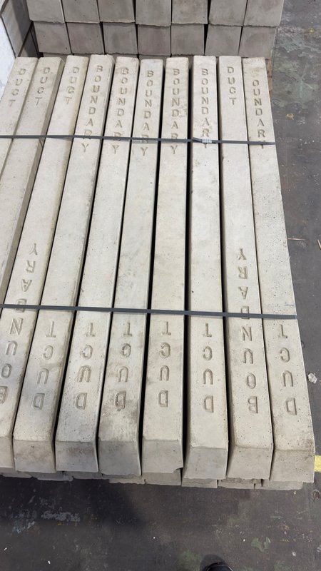 Precast marker posts cast with Boundary and Duct lettering, stacked for despatch