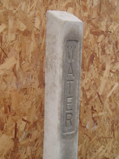 Concrete marker block with the word WATER cast into its face