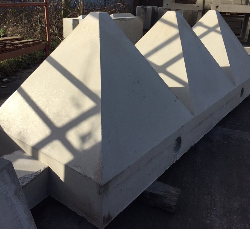 Tank trap pyramid barriers, or dragon's teeth, stored in a yard