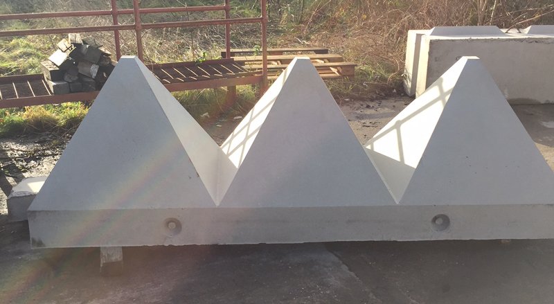 Tank trap pyramid barrier unit with three pyramids cast on a single base beam