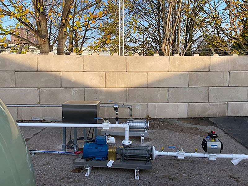 Blast wall of stacked precast blocks behind a gas pump skid