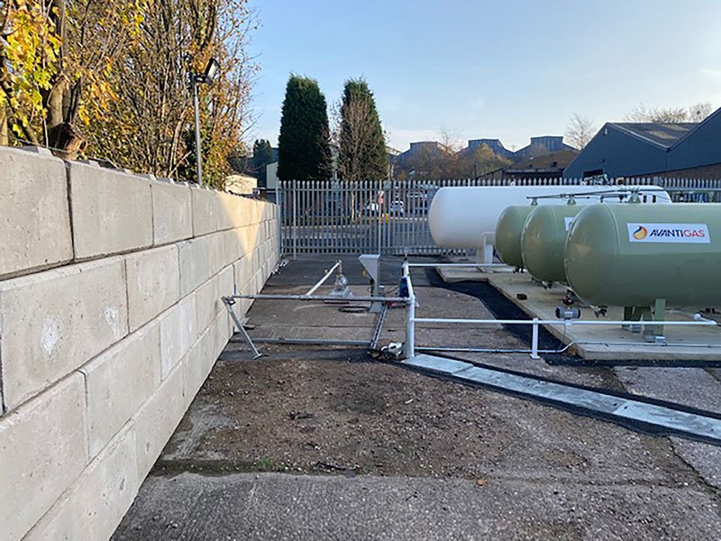 Low precast block blast wall enclosing two bulk gas storage tanks
