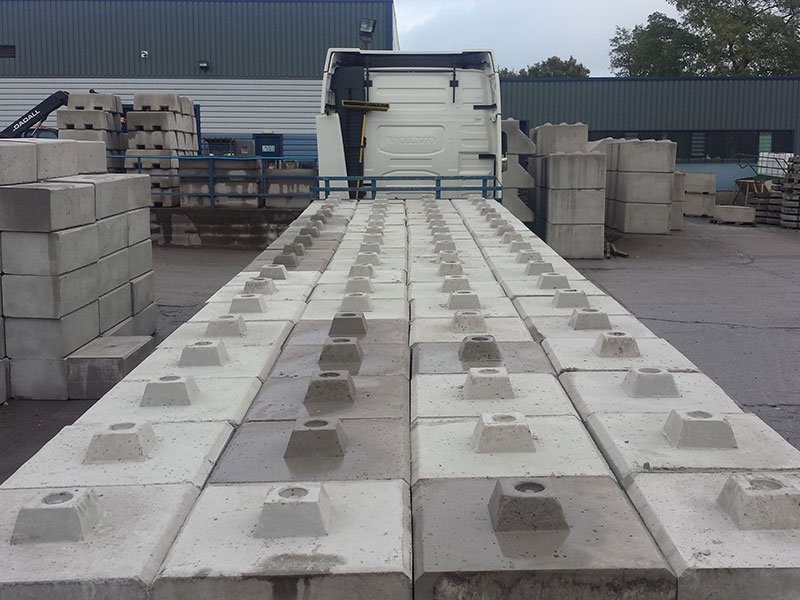 Rows of Duo interlocking blocks laid out in a yard beside a delivery lorry