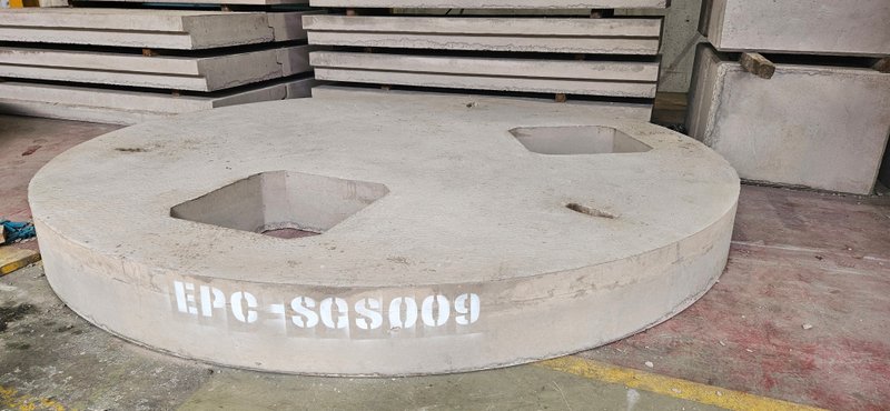Circular cover slab marked EPC-SGS009 with two square openings in the works