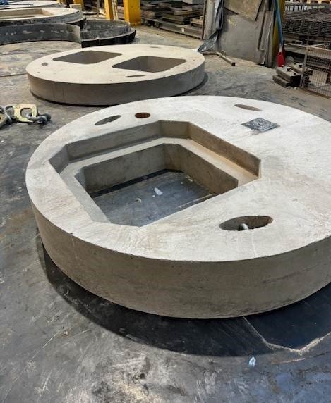 Large circular bespoke cover slabs with shaped cut outs on a factory floor
