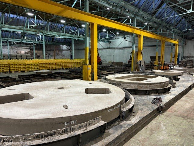 Large circular access cover slabs with cast openings on a factory floor