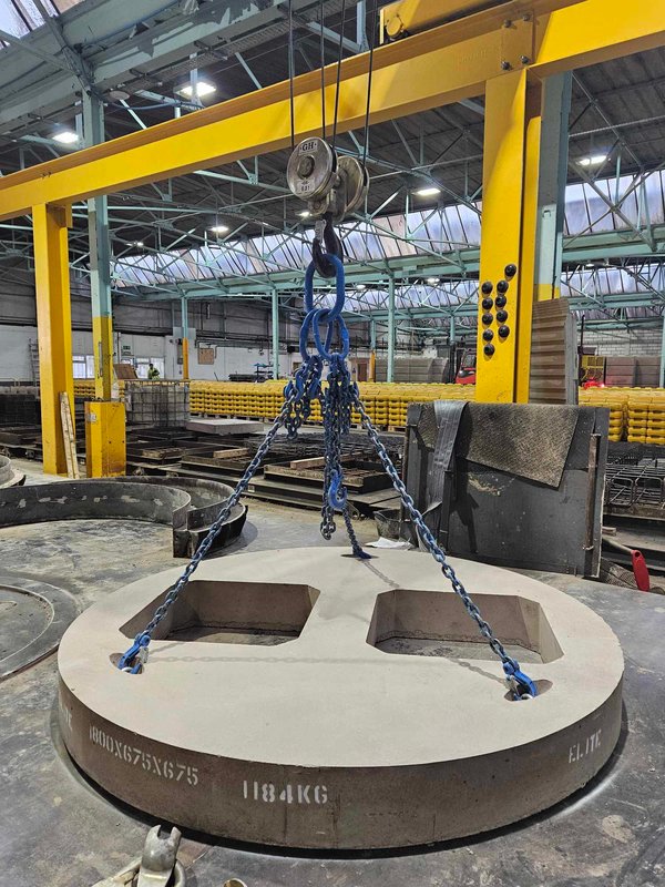 Circular bespoke cover slab lifted on chains from an overhead gantry crane