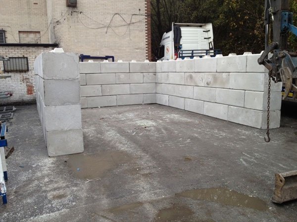 Duo blocks forming a three-sided storage bay in a wet yard