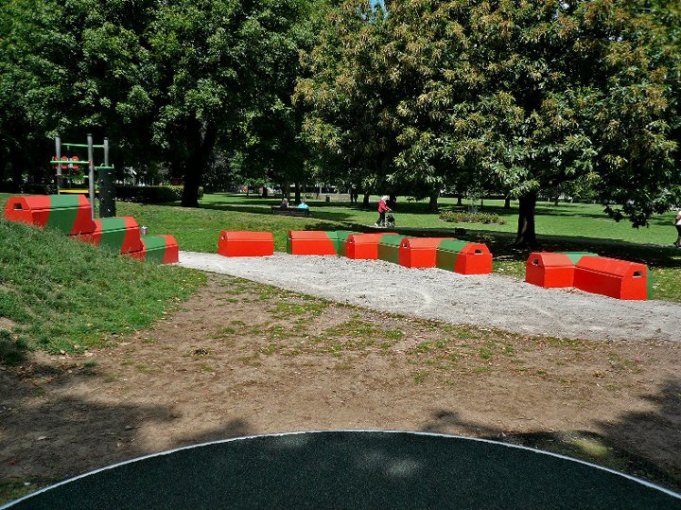 Duo blocks painted red forming play features around a park sand pit