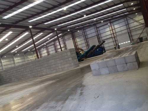Duo interlocking blocks being built into a push wall inside a warehouse