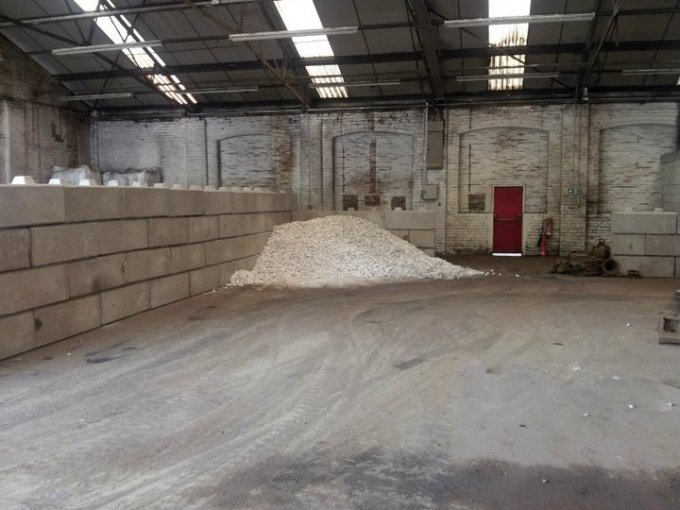 Duo block walls lining a warehouse interior around a stockpile of material