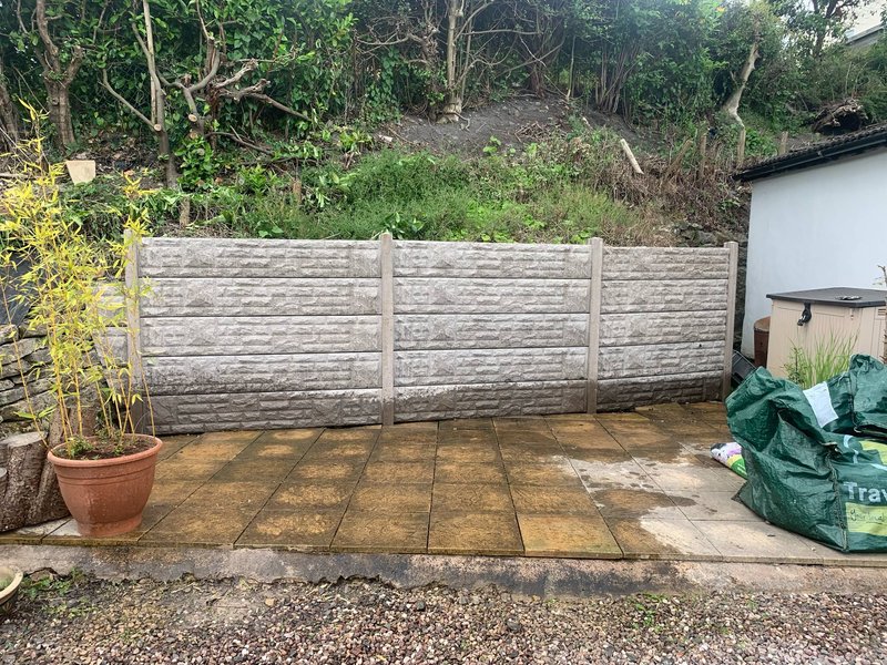 Decorative concrete fence panels and posts enclosing a domestic garden