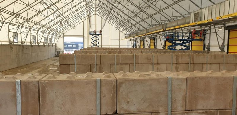 Legato block bay walls holding stored material inside a large processing shed