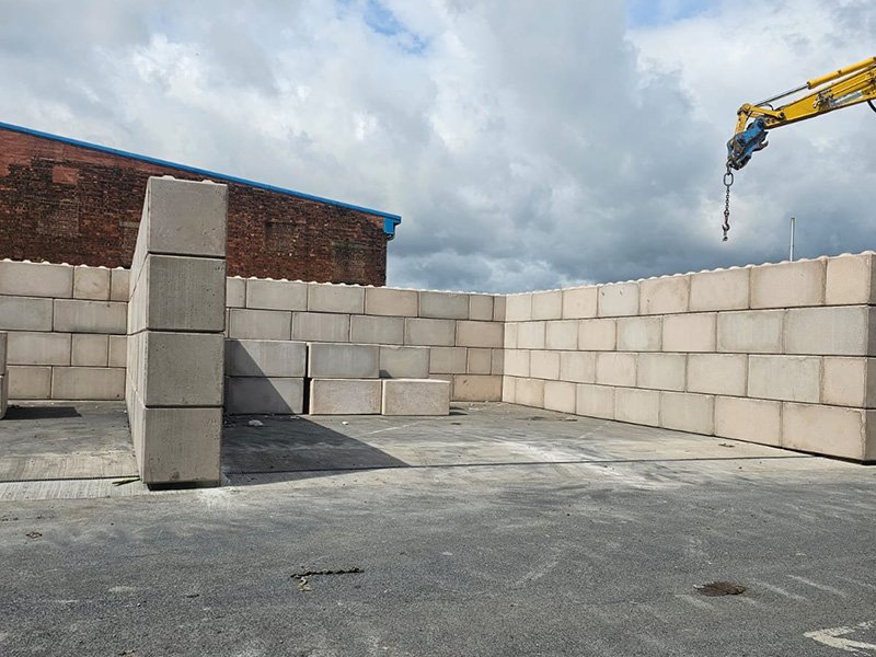 Interlocking block walls forming a vehicle safety bay in a yard