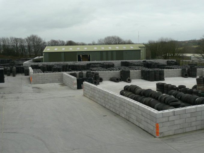 Duo interlocking blocks forming low storage bays holding tyres in a yard