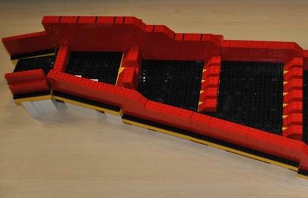 Red-painted scale model of a stepped interlocking block walling scheme