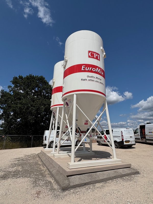 Cement silo mounted on a precast concrete foundation base slab in a site compound