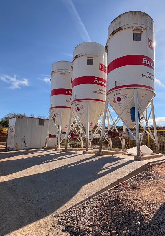 Cement silos standing on precast foundation base slabs on concrete hardstanding