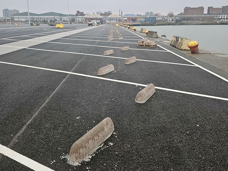 Precast concrete HGV wheel stops set out across a marked lorry parking area