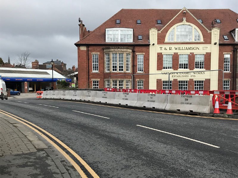 Jersey barriers lining a town-centre carriageway to protect works outside a building