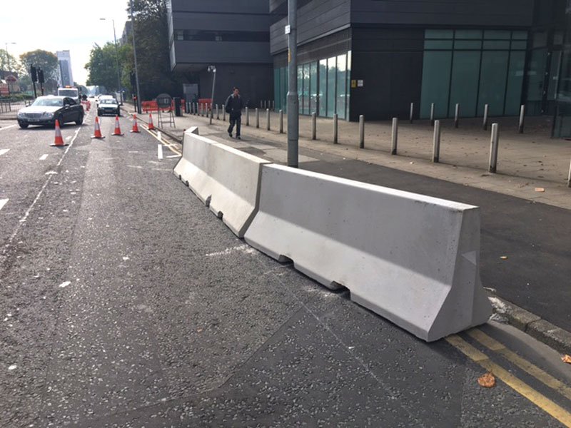 Jersey barriers set along a city street to separate traffic from pedestrians