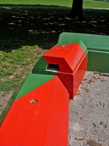Duo interlocking blocks painted red and green as play features in a park