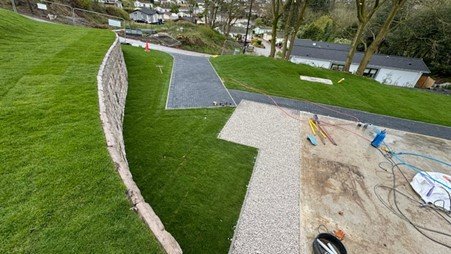 Curved Retainer-Rock wall retaining a landscaped lawn and paths at a lodge park