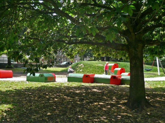 Painted Duo blocks arranged as play features on a shaded grassy play area